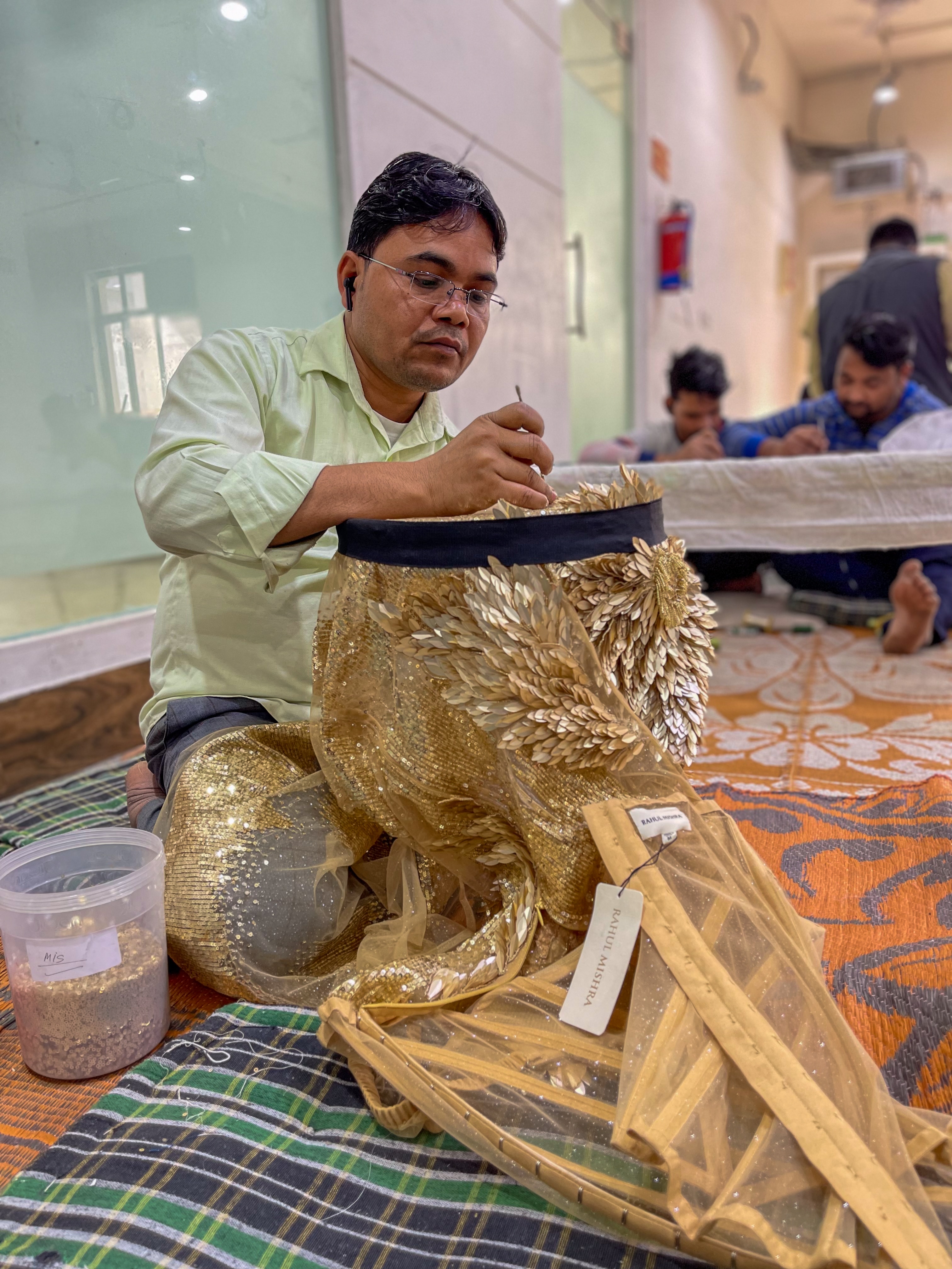 A man working on a gold garment