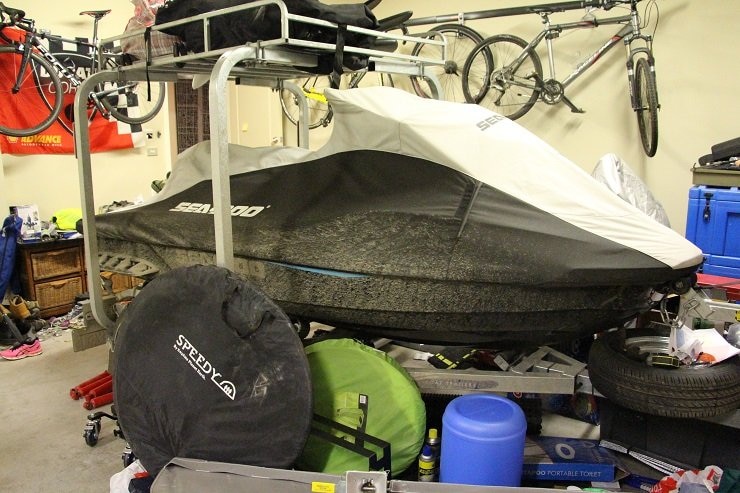 A jetski on a trailer, in a garage.
