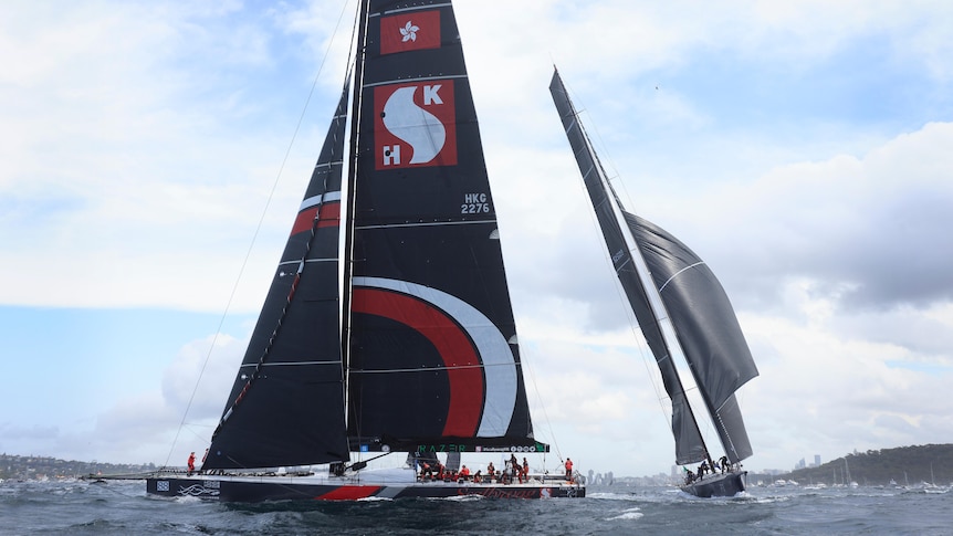 SHK Scallywag, with the Hong Kong flag on it black sail, off Sydney with other yachts around it.