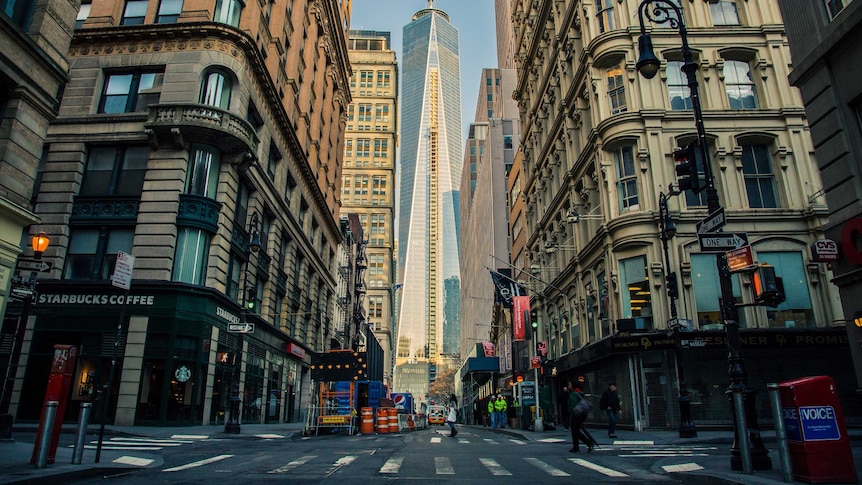 One World Trade Center in New York seen from street level between buildings.