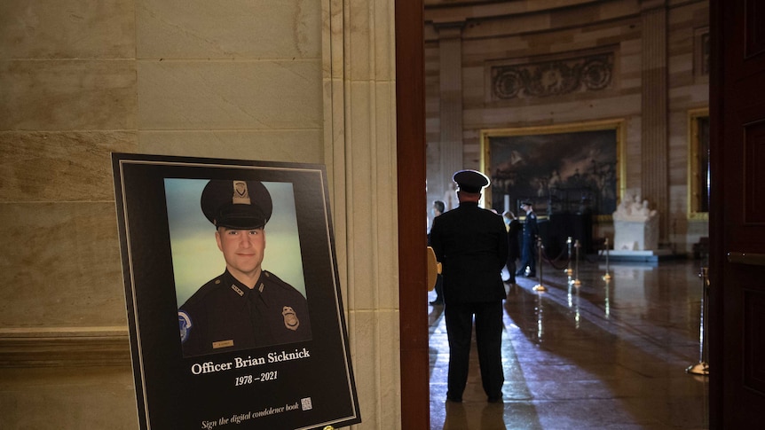 A placard is displayed with an image of the late US Capitol Police officer Brian Sicknick