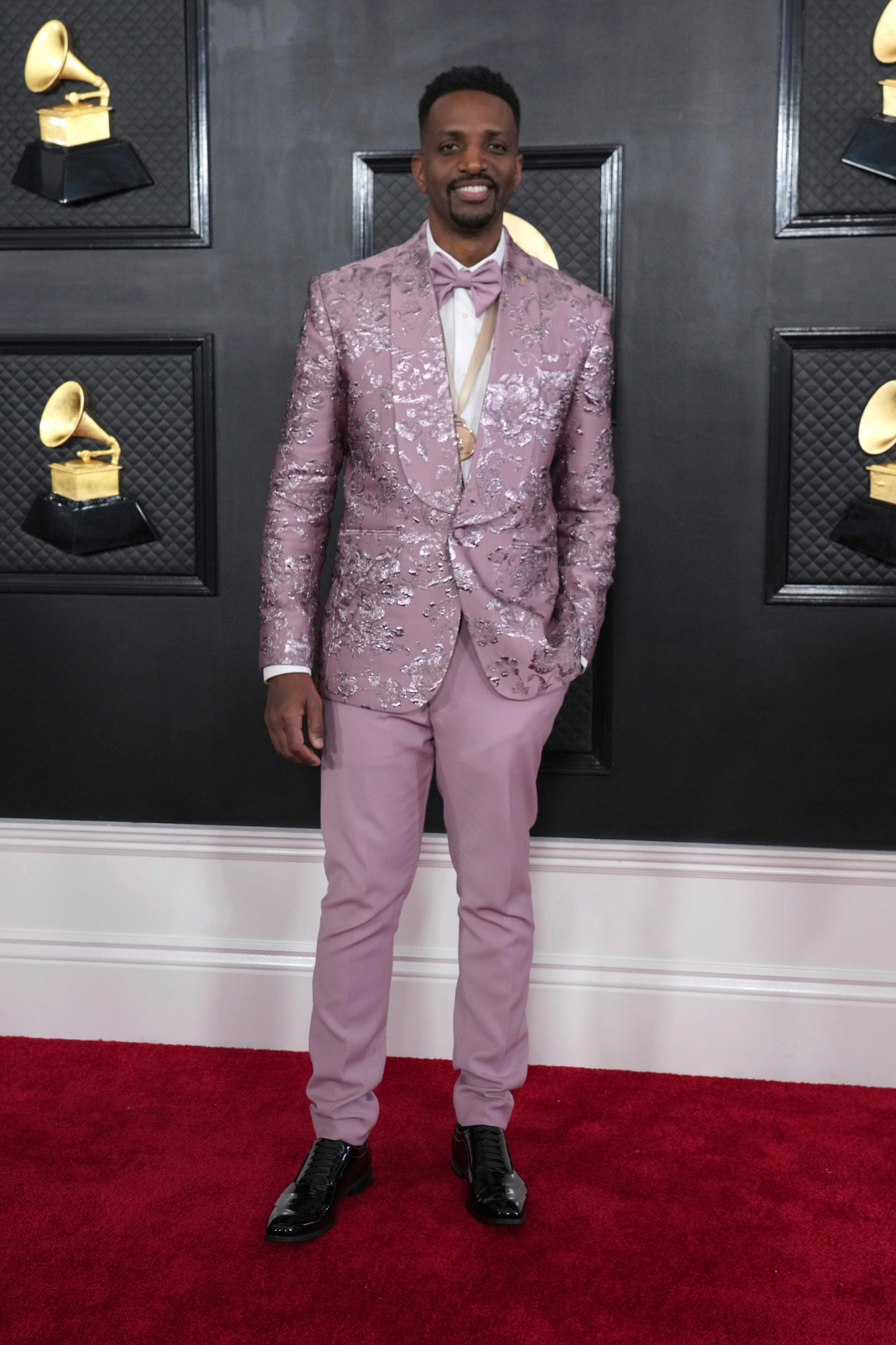 J. Ivy wearing a pastel pink suit with silvery floral detailing on the jacket. 