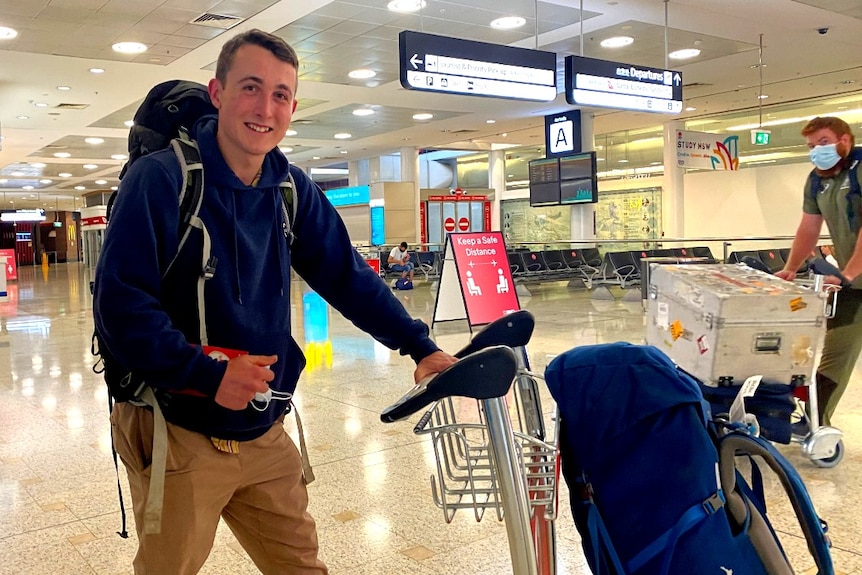 James Lee holds a trolley with his bags at Sydney Airport.