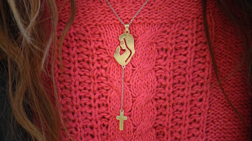 A Christian locket showing Mary and the cross around the neck of a Syrian refugee in Sydney.