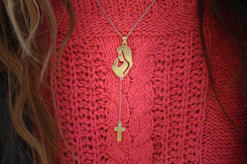 A Christian locket showing Mary and the cross around the neck of a Syrian refugee in Sydney.