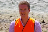 WA Environment Minister Albert Jacob in a hi-vis vest while visiting the Swan River wetlands.