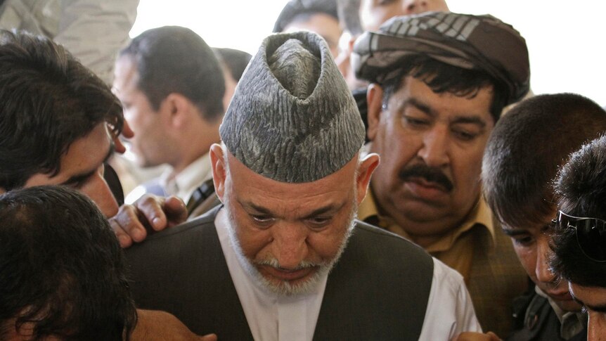 Hamid Karzai weeps at brother's funeral.