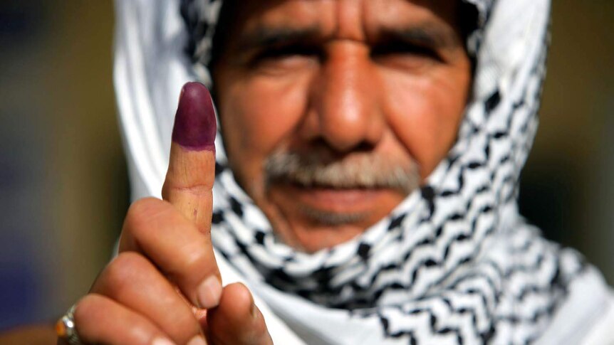 A man shows off his inked finger after voting in Iraq's first elections