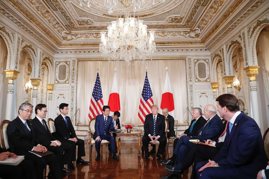 Donald Trump and Japanese Prime Minister Shinzo Abe listen during a meeting.