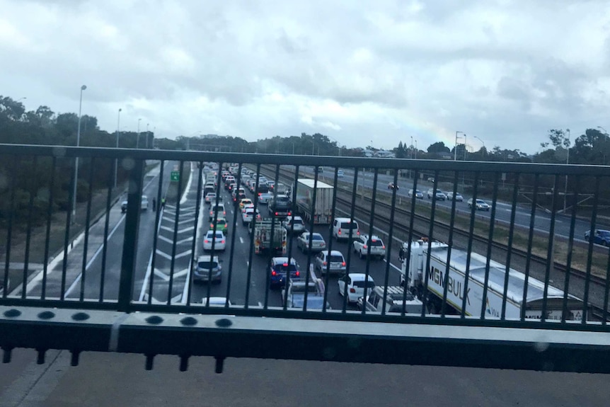 A traffic jam on the freeway as viewed from an overpass.