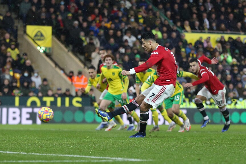 Cristiano Ronaldo swings his right foot through the ball to blast a penalty kick into the net for Manchester United.