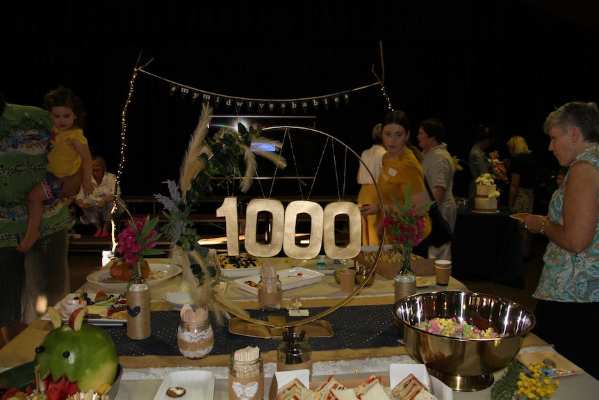 1000 decorations hangs on a table with snacks, with people in the background