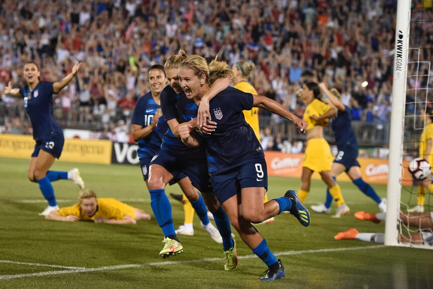 Lindsey Horan wheels away with McCall Zerboni hugging her after scoring