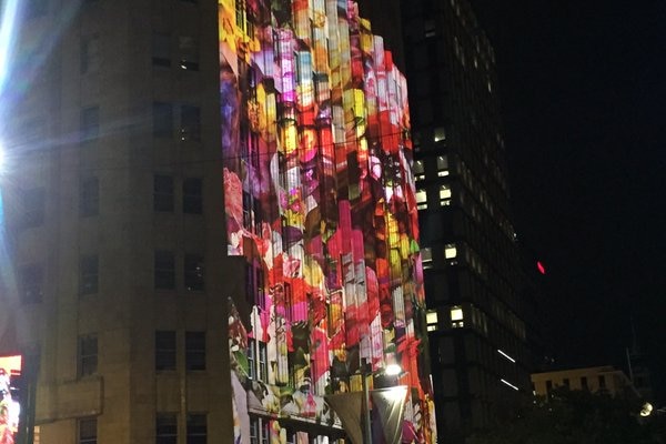 A colourful floral projection lights up a building facade.