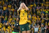 Caitlin Foord reacts to missing a goal with hands on head.
