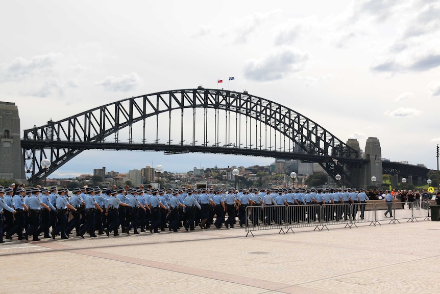 Officers march past the Sydney Harbour Bridge