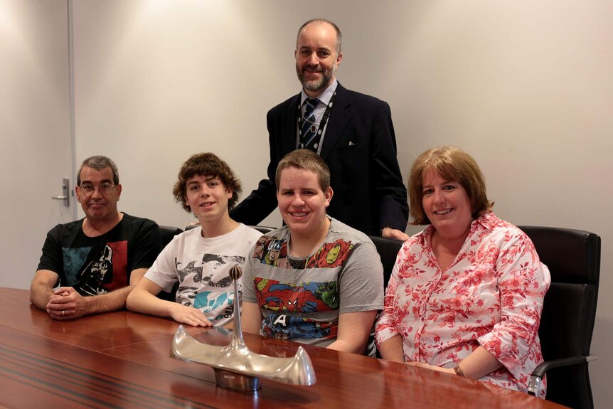 Julie Jones and her family with Dom Appay, manager of research and development at the Royal Australian Mint, viewing the Clements centrepiece.