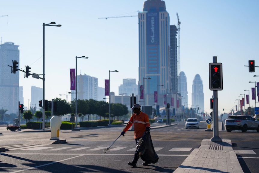 A municipal worker is the only person visible on the street in downtown Lusail