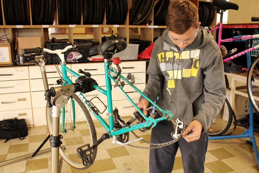 Bradyn Lawson working on a bike in the collective workshop in Risdon Vale.