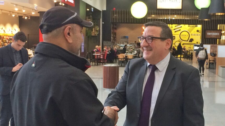 Smiling Steve Georganas (R) shakes a constituent's hand