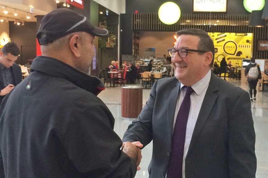 Smiling Steve Georganas (R) shakes a constituent's hand