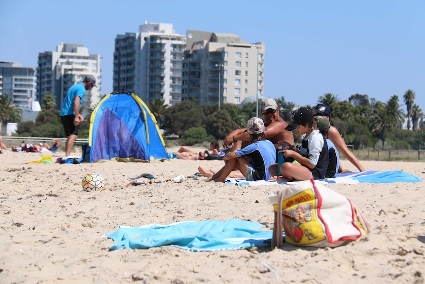 Beachgoers try to cool off in hot weather at Port Melbourne.