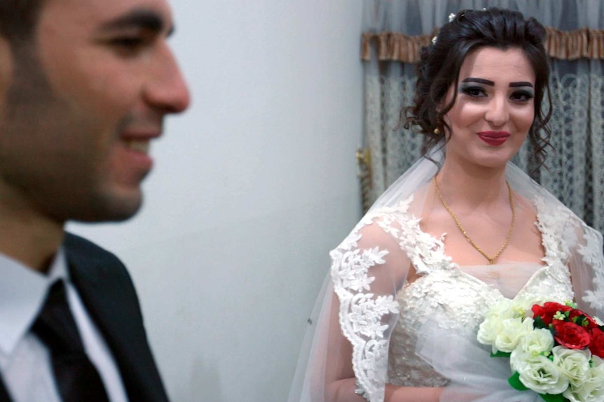 Bride Bercem (right) looks over at her groom Azad (left).