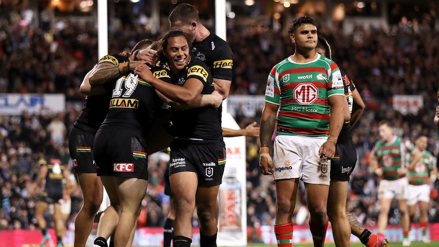 A group of rugby league players celebrate a try 