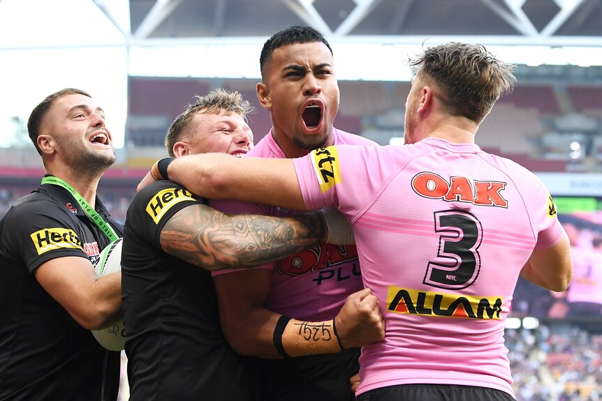 Penrith Panthers' Stephen Crichton is embraced by teammates after a try in the NRL preliminary final against Melbourne Storm.