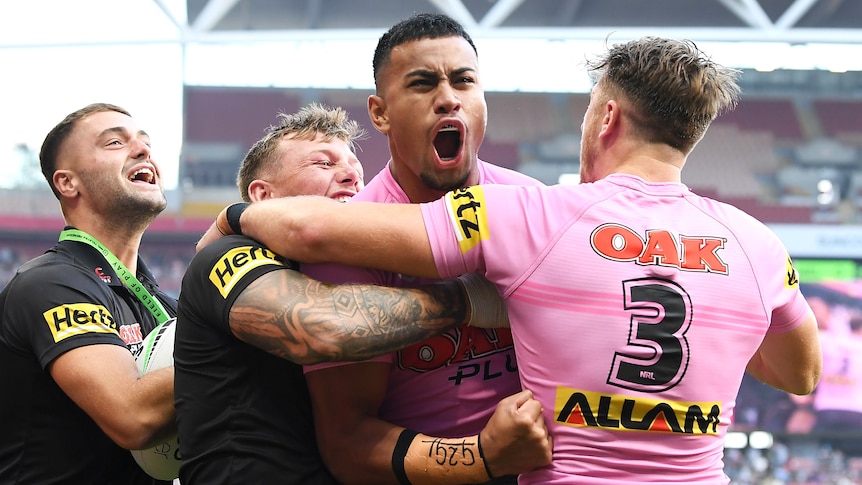 Penrith Panthers' Stephen Crichton is embraced by teammates after a try in the NRL preliminary final against Melbourne Storm.