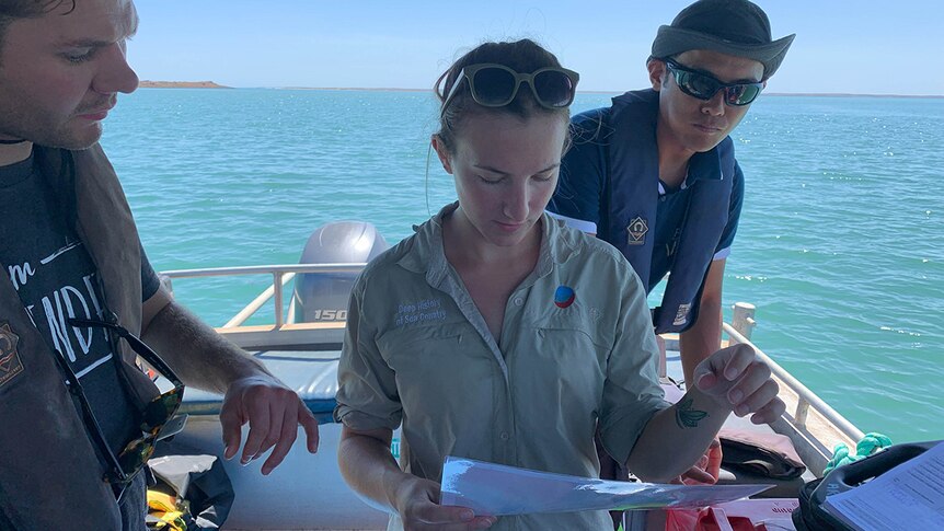 Flinders Archaeology PhD Candidate Chelsea Wiseman is pictured studying a map to decide where the team will dive next.