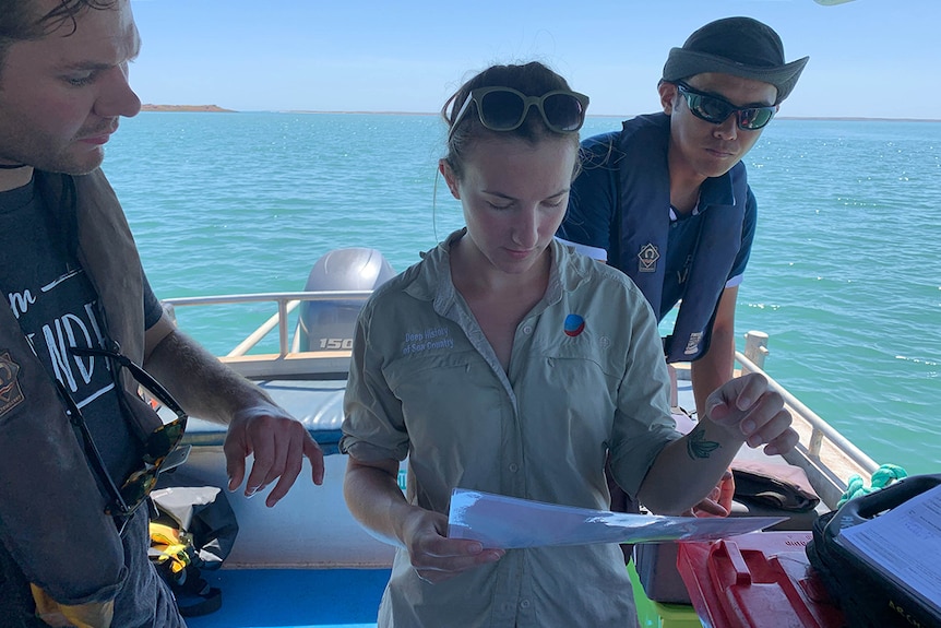 Flinders Archaeology PhD Candidate Chelsea Wiseman is pictured studying a map to decide where the team will dive next.