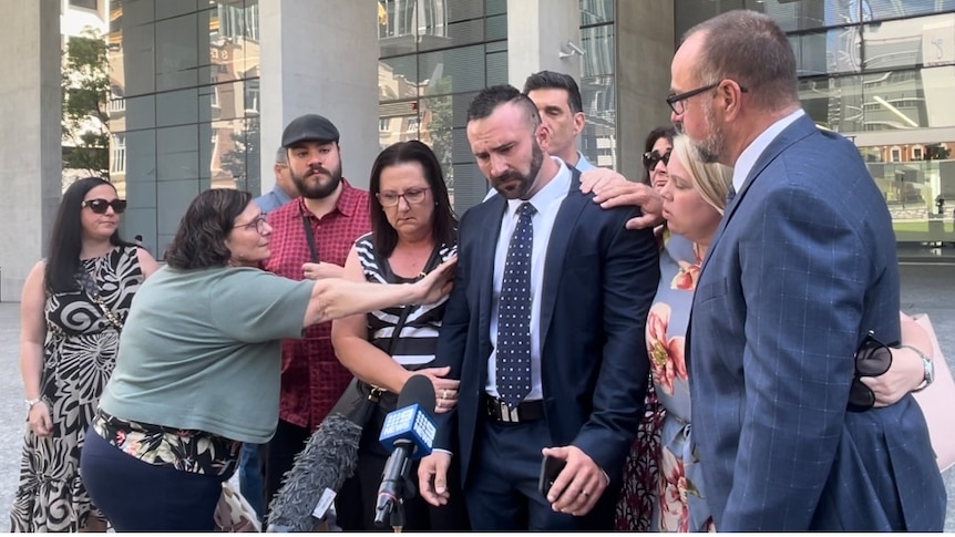 james puglia overcome with emotion, comforted by family as he speaks outside court