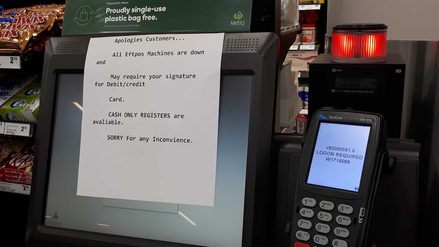 A sign at the supermarket Woolworths advises customers than all Eftpos machines are down.