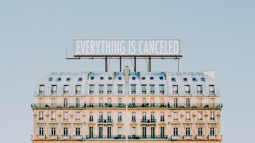 A sign saying 'Everything is canceled' sits atop a building.