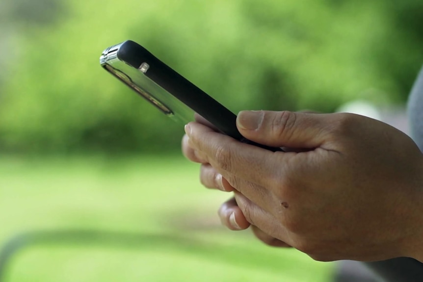 a close up of a woman's hands holding onto a mobile phone