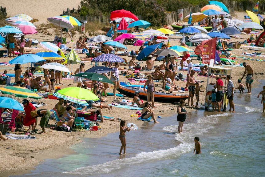 A crowded beach with colourful umbrellas