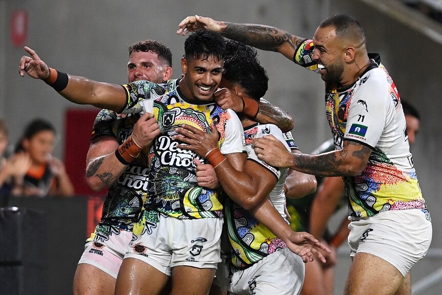 A group of rugby league players celebrate a try 