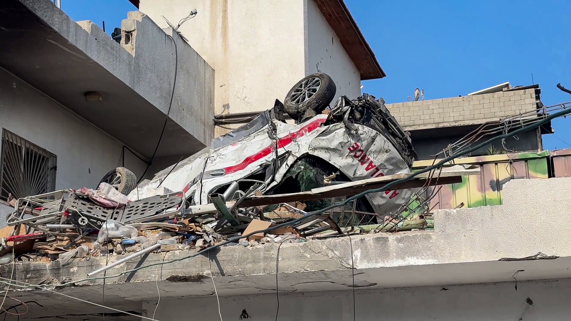 An upturned, destroyed ambulance sits atop the roof of the besieged Kamal Adwan hospital in Northern Gaza.