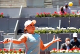 Ash Barty rises up to hit a forehand at the Madrid Open tennis tournament.
