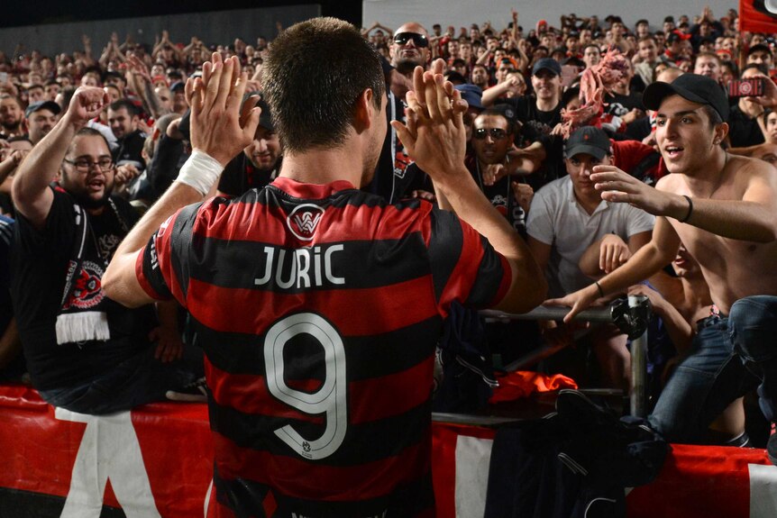 Wanderers' Tomi Juric celebrates a win over Adelaide with the Red and Black Bloc.