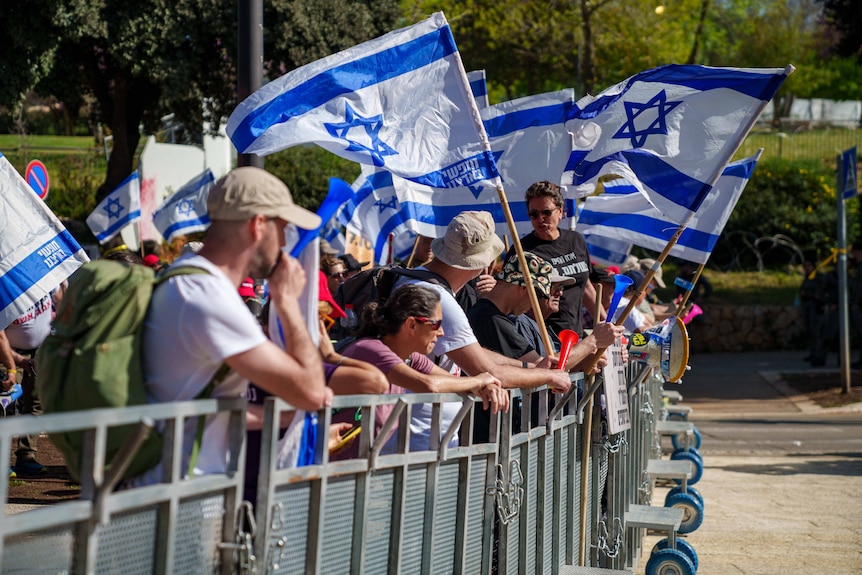 A group of people holding Israeli flags.