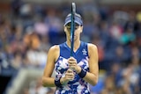 Ajla Tomljanovic holds a tennis racquet up to her her face and closes her eyes during a match at the US Open.