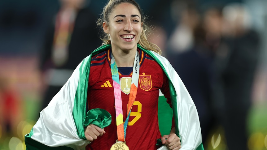 Olga Carmona smiles with her World Cup winner's medal around her neck