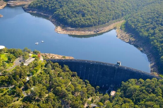 Aerial view of large dam surrounded by bushland