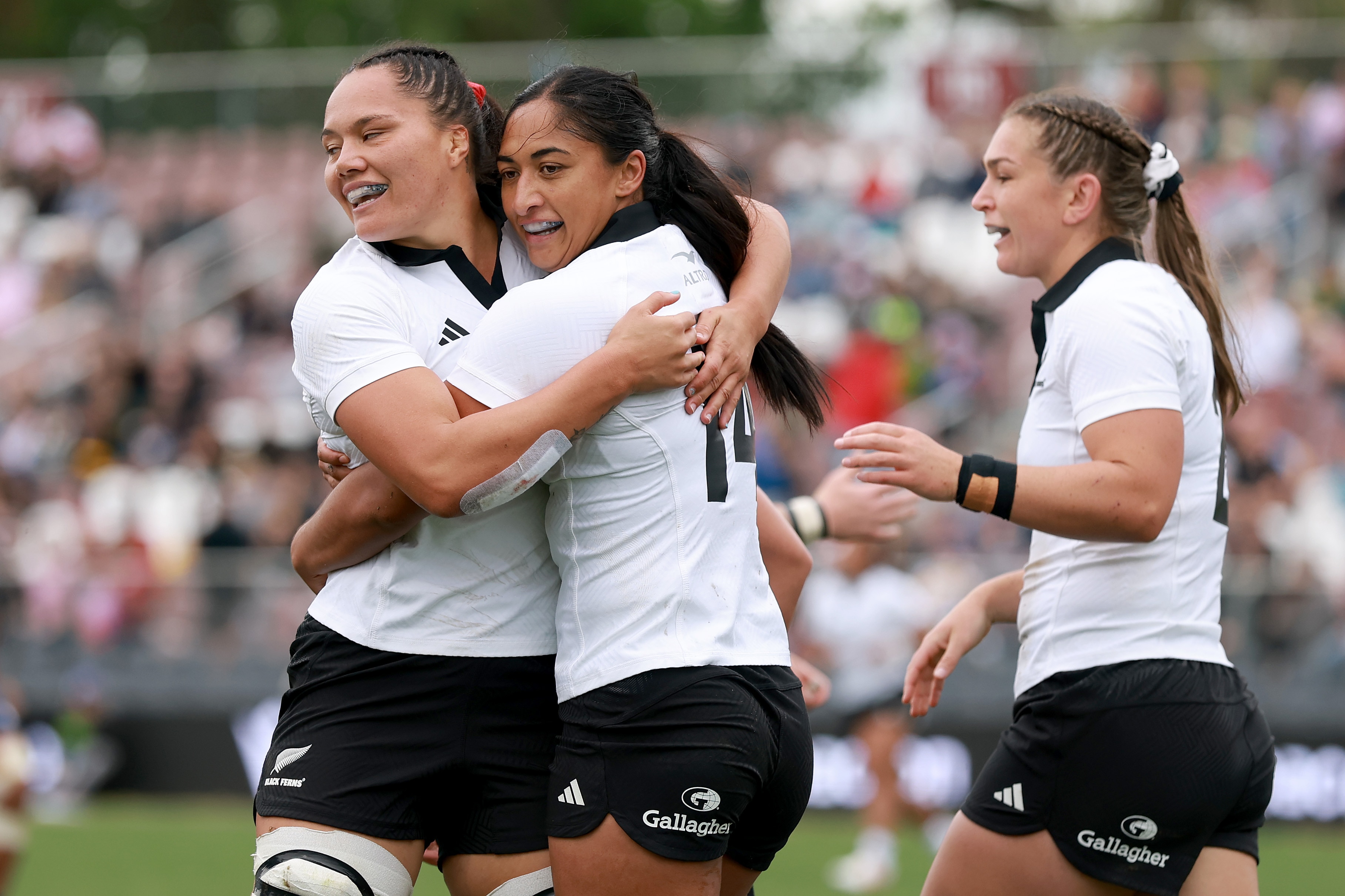 Three Black Ferns players celebrate a try against the United States.