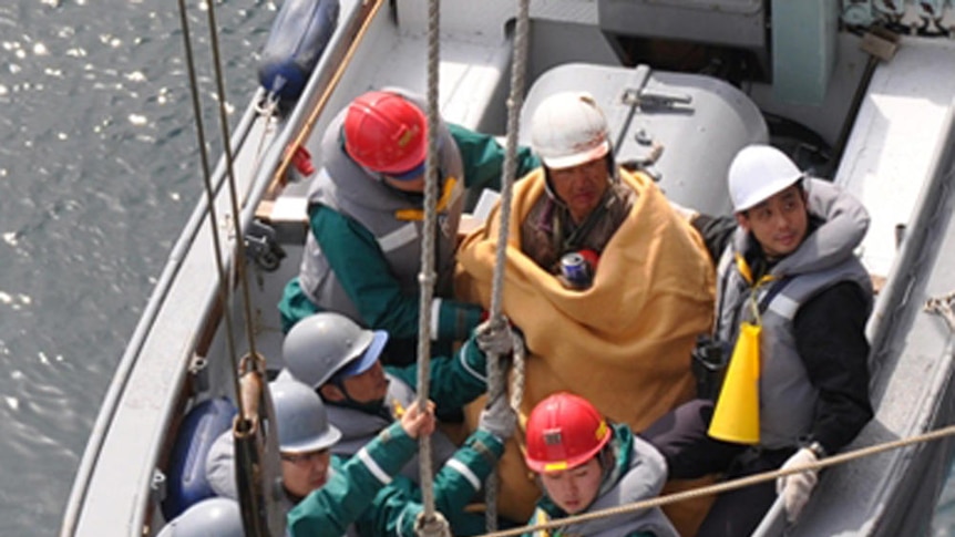 Rescued: sixty-year-old survivor Hiromitsu Shinkawa with Japan Maritime Self-Defence Force crew.