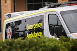 An ambulance in front of a red brick building.