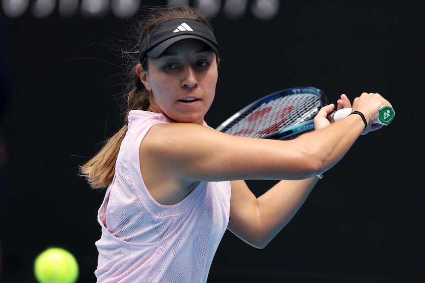 An American female professional player hits a backhand at the Australian Open.