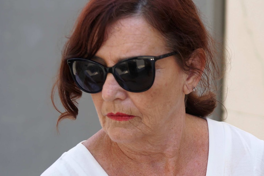 A tight head shot of Margaret Dodd outside court wearing sunglasses.